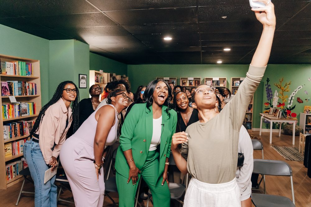 Danielle laughing in a group selfie with readers at a bookstore event